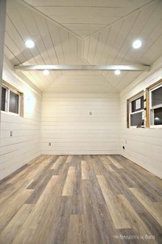 an empty room with wood floors and white walls