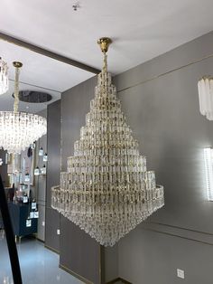 a large chandelier hanging from the ceiling in a room with mirrors and lights