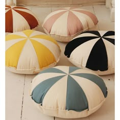 four different colored pillows sitting on the floor