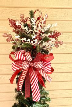 a christmas tree decorated with red and white ribbons