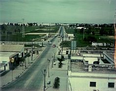 an aerial view of a street with cars driving down it