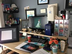 a desk with a computer monitor, keyboard and various other items on top of it