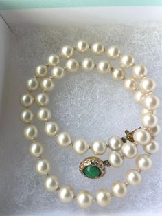 Step back in time with this elegant White Akoya Pearl Necklace, a Single Strand Pearl Necklace with a Jade Cabochon closure, a timeless piece of jewelry from the 1940s  that exudes classic sophistication and grace. This beautiful single strand necklace features lustrous cabochon pearls, each carefully selected for their radiant glow and smooth texture. Adding a touch of unique charm, the necklace is accented with a striking green jade cabochon, creating a captivating contrast that enhances the o Luxury Vintage Akoya Pearl Jewelry, Elegant Vintage Charm Jewelry, Elegant Necklace With Box Clasp For Gifts, Antique Pearl Necklace For Formal Occasions, Elegant Vintage Charm Jewelry For Anniversary, Vintage Yellow Gold Single Strand Necklace, Elegant Vintage Charm Bracelets For Anniversary, Elegant Vintage Charm Bracelet For Anniversary, Vintage Single Strand Jewelry For Wedding