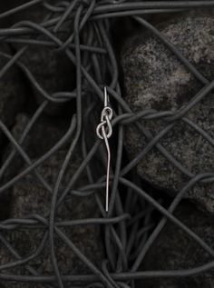 This mono earring features a sleek strand of silver elegantly tied in a knot. A self-contained piece of jewellery. Sterling silver, rhodium plating. Knot, Sleek, Plating, Sterling Silver, Silver