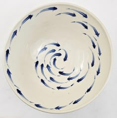 a blue and white bowl with black fish in it's spiral design on the bottom