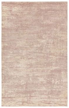 an area rug with light pink and beige colors on the floor, it is made out of