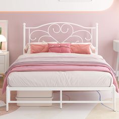 a white bed sitting next to a pink wall