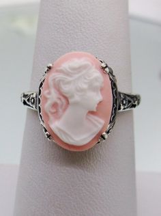 Cameo Ring  Edward Design#70 Made To Order Here we have an Edwardian reproduction ring in sterling silver filigree with a light pink and white cameo that details a classic lady silhouette. This beautiful cameo measures 14mm in length and 10mm in width. This ring also sits 7mm off the finger. The inside of the band is marked 925 for solid sterling. Notice the beautiful leaf and floral design of the filigree setting and etched band. This is a lovely rendition of an Antique filigree ring.  This ama White Oval Carved Rings, Lady Silhouette, Floral Filigree, Antique Filigree, Filigree Jewelry, Cameo Ring, Silver Lights, Sterling Silver Filigree, Jewelry Antique