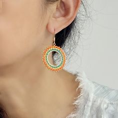 Add a pop of vibrant color to your ensemble with these stunning Orange hoop Boho style handmade earrings. The oversized circles feature intricate brick stitch beadwork using high-quality Miyuki Delica seed beads, creating a truly unique and eye-catching accessory. These big, bold earrings are perfect for those who love adding a touch of bohemian flair to their look. Stand out from the crowd with these one-of-a-kind statement earrings that are sure to turn heads wherever you go. Closure: Ear hook Diameter: 1.32 inches Quantity:1 pair Bohemian Hoop Beaded Earrings With Colorful Beads, Colorful Beaded Circle Earrings For Summer, Colorful Circle Beaded Earrings For Summer, Bohemian Beaded Hoop Earrings For Beach, Summer Colorful Beaded Circle Earrings, Colorful Beads Hoop Earrings For Beach, Circular Beaded Earrings For Festivals, Green Beaded Earrings For Summer, Bohemian Circle Earrings With Tiny Beads