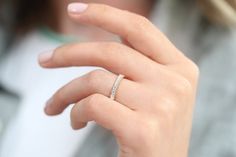 a close up of a person's hand with a diamond ring on their finger