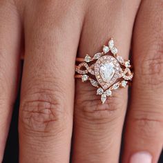 a woman's hand with a wedding ring on it and an engagement band in the middle