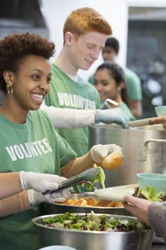 volunteers serving food to people in green shirts at a volunteer event stock photo getty images