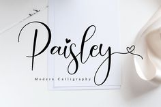 the word paisley written in cursive black ink on a white paper next to a pair of scissors