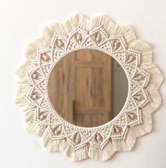 a white doily mirror hanging on the wall