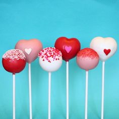 there are many heart shaped lollipops on the stick