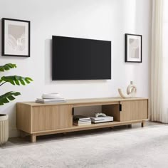 a flat screen tv mounted to the side of a wooden cabinet in a living room