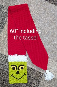 a knitted scarf with a smiling face on it and the words, 60 including the tassel