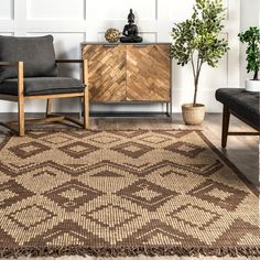 a living room area with a rug, chair and potted plant