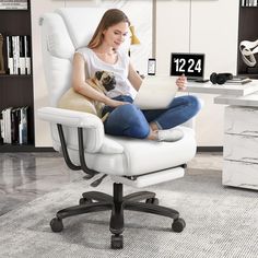 a woman sitting in an office chair with her dog on her lap looking at the calendar