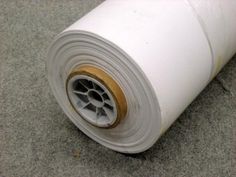 a roll of white fabric sitting on top of a floor