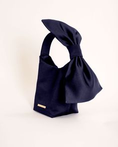 This Camilyn Beth satin Bow Handbag is the perfect combination of chic and unique! A must-have accessory to pair with your Camilyn Beth Design. Details: Satin handbag with adjustable bow detail at handleClosure: MagneticCare: Spot CleanMaterial: Satin Polyester Dimensions: 5" X 4" X 6" Made in: Sarasota, FL. Luxury Shoulder Bag With Bow For Party, Luxury Party Shoulder Bag With Bow, Luxury Formal Shoulder Bag With Bow, Chic Evening Shoulder Bag With Bow, Chic Formal Shoulder Bag With Bow, Rectangular Bag With Bow For Events, Chic Evening Bags With Bow, Elegant Formal Shoulder Bag With Bow, Rectangular Event Bag With Bow Detail