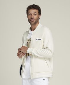 Suit up in timeless sport style. An easy layer to snap over a polo or tee, the Hudson Bomber Jacket brings a touch of luxury to the court. It's made of premium tricot fabric that feels comfortably breathable and wonderfully soft against your skin. Wilson branding accents this bomber, nodding to a hundred-year legacy on the court. | Wilson Men's Hudson Bomber Jacket Sporty Spring Sweatshirt With Logo Detail, Sporty Spring Sweatshirt With Logo, Casual Outerwear With Logo And Baseball Collar, Sporty Winter Outerwear With Logo Detail, Cotton Outerwear With Logo And Crew Neck, Classic Fall Outerwear With Logo Detail, Casual Varsity Jacket With Logo And Baseball Collar, Sporty Long Sleeve Varsity Jacket With Logo, Classic Fall Outerwear With Logo