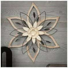 a wooden wall hanging with a metal flower on it