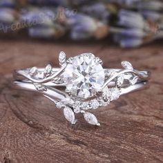 a close up view of a diamond ring on a wooden surface