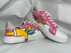 a pair of pink and white shoes with homer simpson painted on the upper part of each shoe