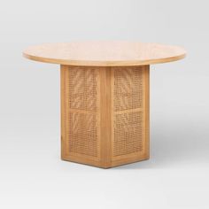 an oval table with perfored wooden panels on the top and bottom, in light wood