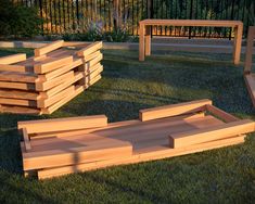 several wooden benches sitting in the grass next to each other