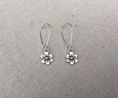 "These are just so sweet and cute! Little daisy dangle earrings. Perfect addition to any outfit and sure to brighten your day! Made from allergy free plated silver. The flowers measure 1/2\" long by 3/8\" wide and hang from 1\" kidney style ear wires that lock and latch. Overall drop length is 1 1/2\". Thanks for stopping by! Please take a moment and visit the rest of my Etsy shop. I have many more unique jewelry designs to choose from! 🌸 Tiger Flower Jewelry 🌸 🌸 Inspired by Nature 🌸" Cute Hypoallergenic Flower Shaped Earrings, Cute Dangle Flower Earrings For Spring, Whimsical Spring Flower Earrings With Ear Wire, Cute Spring Dangle Flower Earrings, Cute Nickel-free Flower Earrings, Cute Spring Flower Dangle Earrings, Cute Nickel-free Flower Shaped Earrings, Cute Spring Earrings With Ear Wire, Cute Flower Shaped Hypoallergenic Earrings