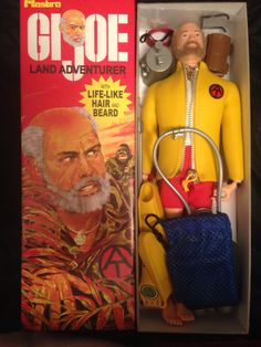 an action figure in a box with a keychain and other items around it