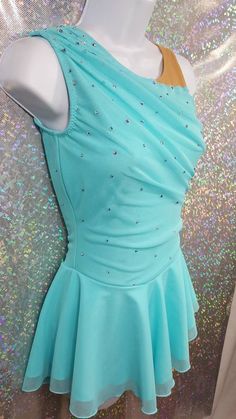 a woman's blue dress with sequins on the shoulders and back, sitting on a mannequin