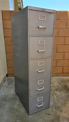 a metal filing cabinet sitting on top of a cement floor