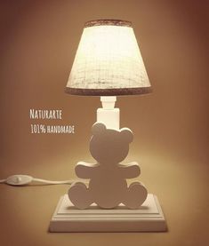 a teddy bear lamp sitting on top of a table next to a white light bulb