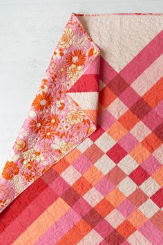 an orange and pink quilt on top of each other