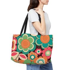 "Retro Hippie Weekender Tote Bag.  Vintage Design in groovy throwback colors and its roomy!  Groovy Retro Flower Weekender tote bag.  Throwback colors of orange, blue, green, and pink encase this sturdy vacation bag.  Great catch-all for those events when you need to bring things along.   Perfect for the hippy boho lover.  This personalized weekender bag comes in one size - 24\" x 13\" (60.9 cm x 33 cm) - perfect for those who love to travel light. Its t-bottom construction and black handles give it a sleek, classic look. Design is on 100% spun polyester in vibrant colors. .: 100% Spun Polyester .: One size: 24\" x 13\" (60.9 cm x 33 cm) .: Black interior lining .: T-bottom construction .: All-over print .: Assembled in the USA from globally sourced parts Visit our shop for more bags and a Retro Green Shoulder Bag With Large Capacity, Retro Green Tote Shoulder Bag, Retro Green Everyday Bag, Green Retro Everyday Bag, Green Retro Shoulder Bag For Shopping, Retro Green Tote Bag, Colorful Retro Tote Bag, Retro Multicolor Large Capacity Bag, Retro Multicolor Bag With Large Capacity