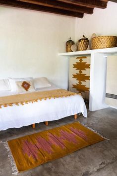 a bedroom with a bed and rugs in it