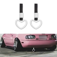 two heart shaped headphones attached to the front of a pink car