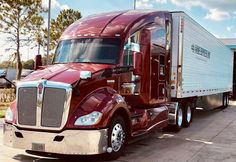 a red semi truck parked in front of a building