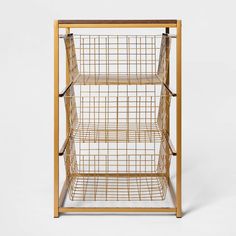 a wooden shelf with three shelves and wire baskets on top, against a white background