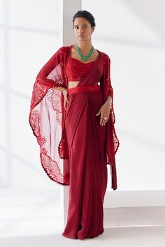 Red pre-draped plain saree crafted in crepe. Paired with a cape sleeves yemeni bloom embroidered cape using tonal thread, sequins, beads, mirror highlights, embellished padded blouse and hand embroidered belt. - Aza Fashions Red Pre-draped Saree For Party, Red Pre-draped Saree For Evening With Traditional Drape, Red Draped Saree For Festive Occasions, Red Floor-length Pre-draped Saree For Wedding, Red Draped Saree With Dupatta, Red Draped Dupatta Set, Red Draped Lehenga For Festive Occasions, Red Floor-length Pre-draped Saree With Pallu, Red Draped Saree For Diwali