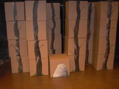 several cardboard boxes with trees painted on them and one box sitting in front of it