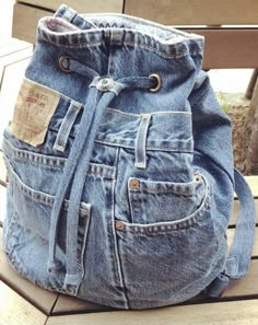 a denim purse sitting on top of a wooden bench