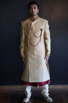 The Gold and Maroon Sherwani is beautifully designed on a satin/silk material embroidered in gold. Comes with a Gold Pajama and Maroon kurta. Can be altered to size for an additional cost. Measurements are listed as below: Sherwani Length: 44 inches  Sleeve Length:  26 inches Chest Length:  42 inches Kurta Length: 46 inches Kurta Chest: 21 inches Pant: 46 inches Pant Waist: 42 inches Gold Designer Churidar With Traditional Drape, Bollywood Style Fitted Bandhgala With Gold Embroidery, Gold Bollywood Churidar For Designer Wear, Fitted Bollywood Bandhgala With Gold Embroidery, Gold Dabka Dola Silk Sets, Gold Salwar Kameez With Long Sleeves And Embroidery, Designer Gold Salwar Kameez With Traditional Drape, Designer Gold Jamawar Salwar Kameez, Traditional Gold Salwar Kameez With Gold Embroidery