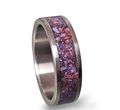 a wedding ring with purple and red stones inlayed to it's center