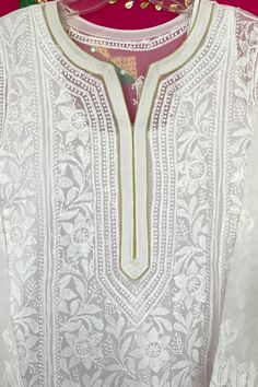 This elegant Georgette Chikankari Long Kurta is a handmade masterpiece, crafted from white fine georgette fabric and adorned with all over heavy resham thread handwork. It features gold piping on the neck and sleeves, adding a touch of sophistication to its design. Length 46" inches Long sleeves 18" inches 1 piece Round neck Side Slit Resham Silk Thread Georgette Chikankari embroidery Dry Clean Fit: True to sizeInside Margin: No Phulkari Pants, Lucknowi Kurta, Gharara Suits, Patiala Salwar Suits, Chikankari Embroidery, Chikankari Kurti, Bridal Dupatta, Phulkari Dupatta, Chikankari Suits