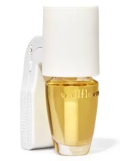 a bottle of perfume next to a white object on a white background with the word wildflower written in gold