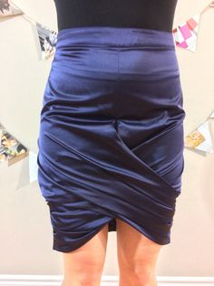 This gorgeous deep purple satin skirt is a piece of art. The fabric is like butter and the zipper on the rear fits perfectly on your curves. We love the gathering at the front to show off your figure. You'll feel like you can take on the world in this sexy skirt. Skirt features logo embossed zipper. Designer: Burberry Size: 6 30" waist 35" hips 19" front 23" back Material Outer: 58% Polyester, 47% Cotton Lining: 100% Cupro Care: Dry Clean or Hand wash Wash, line dry, and steam Condition: Like New (Condition Guide) Retail $1159 Product From Canada, Made in Italy ♥ Sustainable + Ethical Fitted Satin Pencil Skirt For Night Out, Fitted Satin Draped Asymmetrical Skirt, Satin Skirt With Ruched Detail For Night Out, Fitted Satin Pencil Skirt For Evening, Satin Ruched Skirt For Night Out, Chic Satin Pencil Skirt For Party, Evening Satin Fitted Pencil Skirt, Ruched Satin Skirt For Night Out, Elegant Purple Satin Bottoms